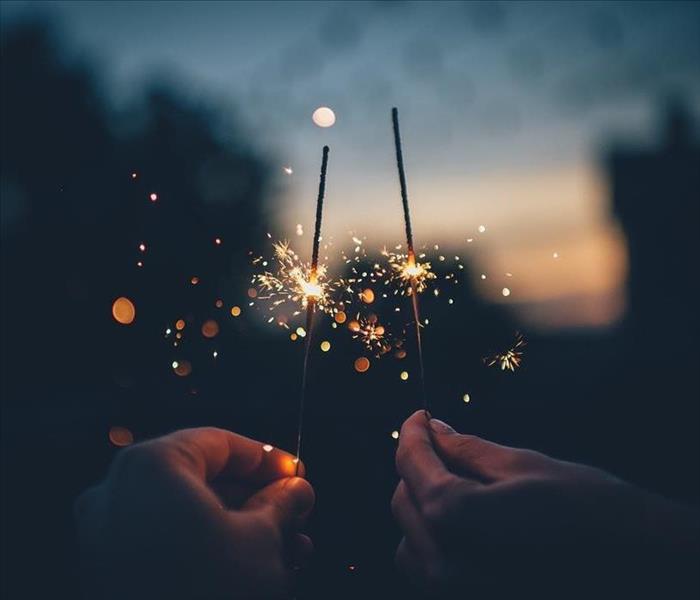 Hands holding lighted sparklers