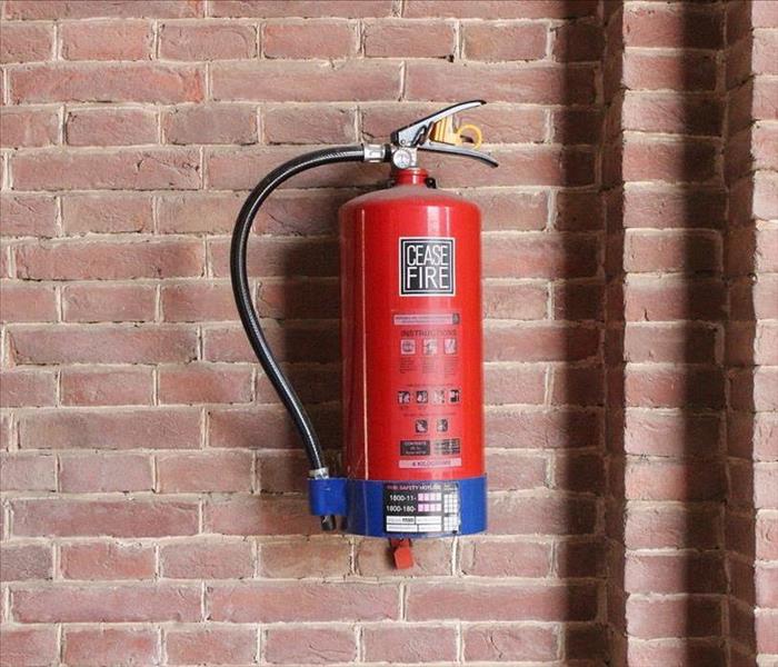 Fire extinguisher hanging on brick wall